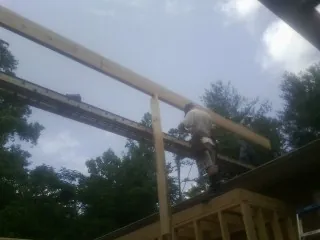 Carpenter setting a ridge beam over a new addition frame — Ice Dam Removal by Roofing Brothers in Kenmare
