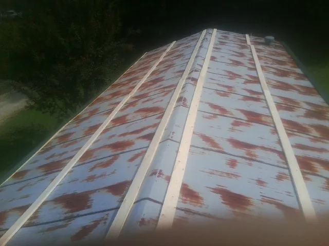 Rusted metal roof panels with new wood purlins before replacement — Storm Damage Roof Repair in Kenmare by Roofing Brothers